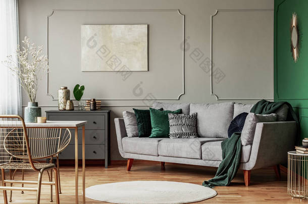 <strong>时尚</strong>的翡翠绿色和灰色客厅室内设计，墙上有抽象绘画