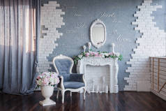 一个灰色的房间, 有一个白色的壁炉和一个灰色的老式椅子, 都装饰着牡丹和美丽的花朵;墙上有一个铭文