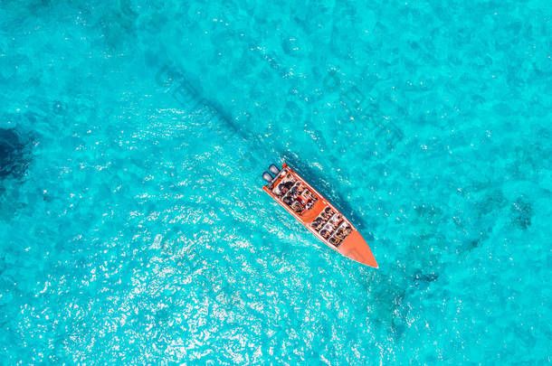 愉快的快艇航行在蓝色清澈的大珊瑚礁清澈的水域与导游。概念旅游船。鸟瞰.