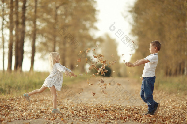 男孩和一个女孩在秋天玩外面