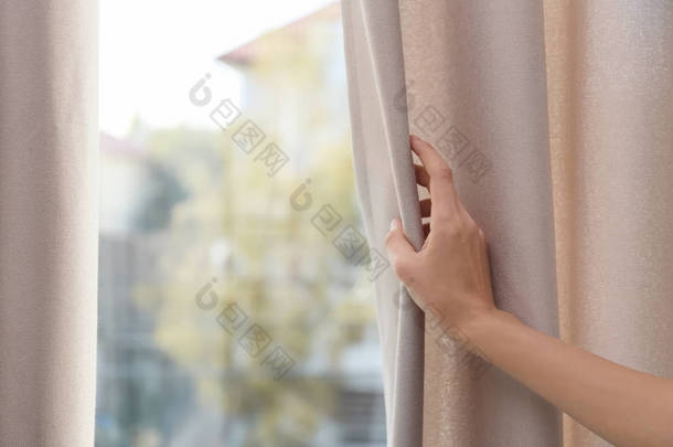 女人在家里打开窗帘, 特写镜头。文本的空间