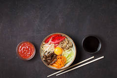 在黑暗背景下的传统亚洲 bibimbap 菜与米和蔬菜