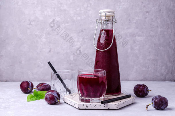 红色李子汁在<strong>玻璃杯</strong>的灰色石头背景与新鲜的水果。有选择的重点.