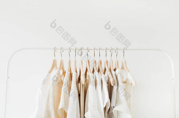 最小的时尚服装概念。白色背景的衣架上的女式上衣和T恤。时尚博客，网站，社交媒体英雄标题.
