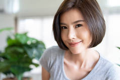 一个快乐的年轻亚洲女孩在客厅里自拍的画像。自然美与健康的女人。人真诚的情感生活理念.