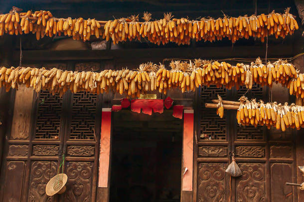 云南<strong>农村</strong>地区，中国古屋屋檐下挂着黄色的玉米芯，用于自然干燥.