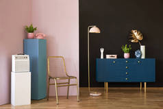 金色椅子, 蓝色橱柜, 灯和白色放大器在一个柔和的房间内