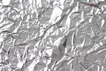 箔。金属皱巴巴的背景。灰色或银色背景图片
