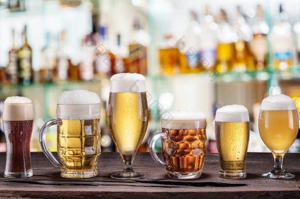 旧木桌上的冷杯子和啤酒杯。酒吧国际
