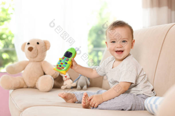 家庭沙发上的玩具手机可爱的小宝宝