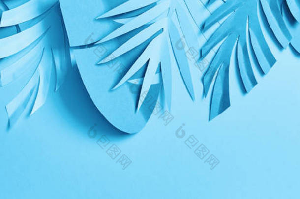 蓝色异国情调的剪纸棕榈叶在蓝色背景与复制空间，全景拍摄