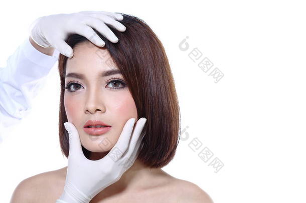 美丽的亚洲女人要在整形手术前检查眼睛、鼻子、眉毛、额头、脸颊、下巴，还要点亮白色背景色作为文字<strong>标识</strong>