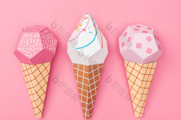 手工制作的彩色折纸冰淇淋圆锥体在粉红色上隔离的顶视图