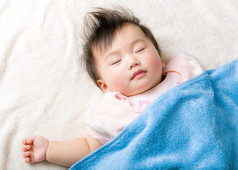 亚洲宝贝女孩睡在毛巾上