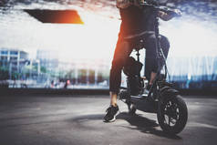 时尚男子嬉皮士准备乘坐电动摩托车在城市。创新的交通.