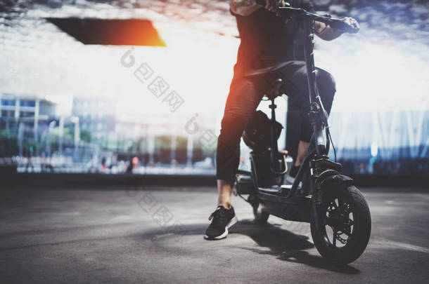 时尚男子嬉皮士准备乘坐电动摩托车在城市。创新的交通.