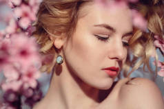 在花园里盛开的桃花树构成的优雅穿着时尚户外写真华丽的年轻女子