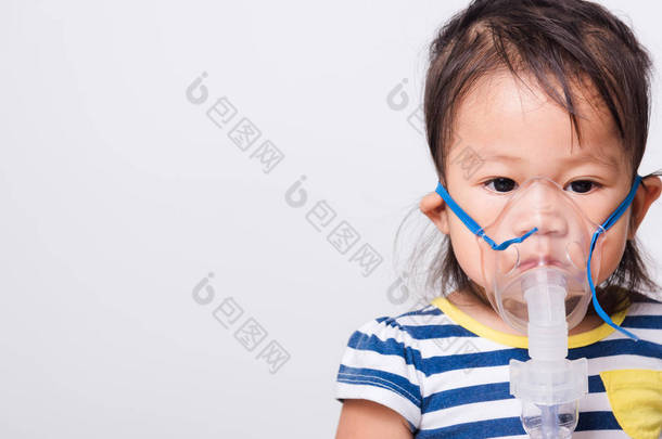 亚洲脸，小女孩用蒸汽机雾化面罩<strong>吸入</strong>自己的白色背景与复印空间，医疗保健
