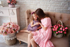 快乐的母亲和女儿，穿着漂亮的衣服，真正的公主们，被鲜花簇拥着，为春天的到来而欢欣鼓舞