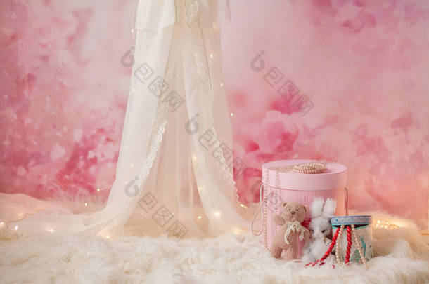 浅色背景上的浅色天篷, 有盒子、珠子和玩具, 女孩的照片区, 拍照的想法