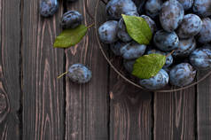 花园的蓝色李子在一个碗上的黑暗质朴的木质背景与复制空间的顶端视图。水果, 维他命, 食物背景
