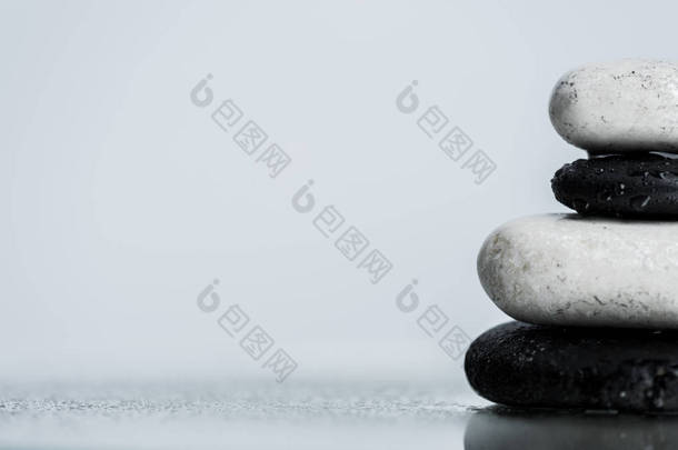 用灰色隔离开的湿玻璃把水滴贴在石头上的近景 