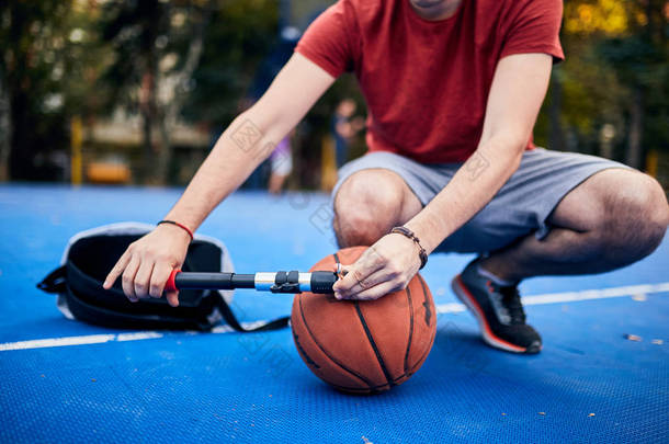 男人在城市里用手泵充气<strong>篮球</strong>运动