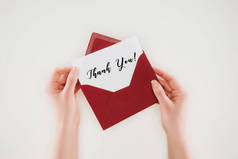 裁剪拍摄的女人打开红色信封与感谢你在纸上孤立的文字在白色