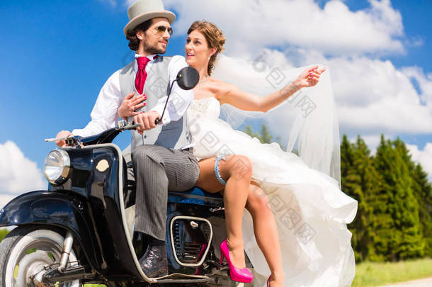 婚礼新郎和新娘驾驶乐趣的小型摩托车 
