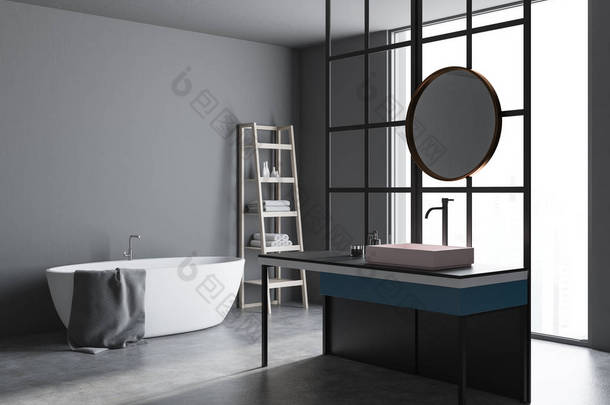 现代浴室的角落里有阁楼的窗户, 一层<strong>混凝土</strong>地板, 一个有圆形镜子的水槽和一个白色的浴缸。灰色的墙壁。3d 渲染模拟