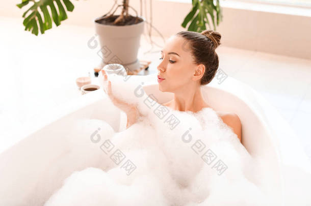 漂亮的年轻女子在浴缸里<strong>放松</strong>
