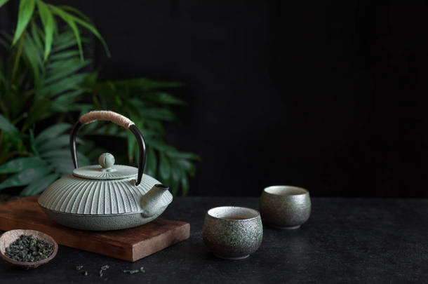 在黑色背景上的茶壶和茶杯, <strong>复制</strong>空间。传统的亚洲安排茶道-铁茶和陶瓷茶杯与茶.