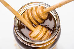 罐子与蜂蜜和木制蜂蜜浸渍隔离在白色 