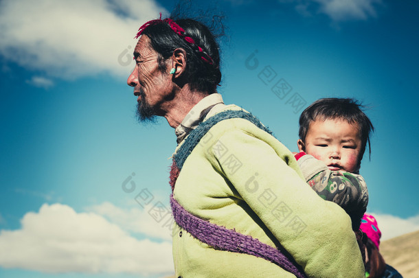 他的孩子在藏北草原的藏族农夫.