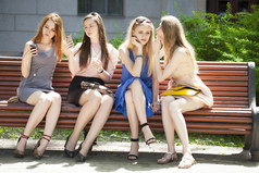 四名少女中夏公园的长椅上坐着 
