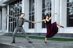 美丽的年轻夫妇在城市街道上练习舞步