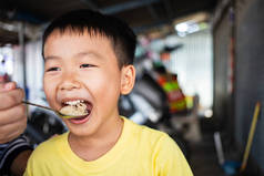 孩子们在泰国街头食品店吃面条