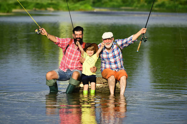 快乐的祖父和孙子正在河里钓鱼. 我喜欢钓鱼。 飞鱼。 父亲、儿子和祖父一起放松一下.