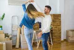美丽的年轻夫妇搬到一个新的家,跳舞在爱庆祝新的公寓