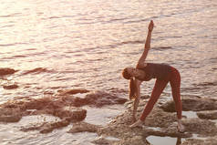 年轻女子在河边练习瑜伽