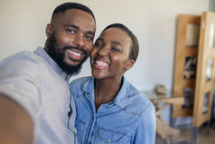 微笑的年轻非洲裔美国夫妇站在他们的客厅在家里一起自拍