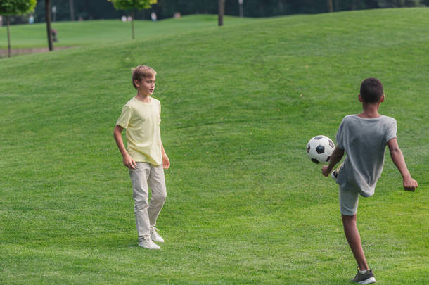 可爱的多元<strong>文化</strong>的孩子在草地上踢<strong>足球</strong> 