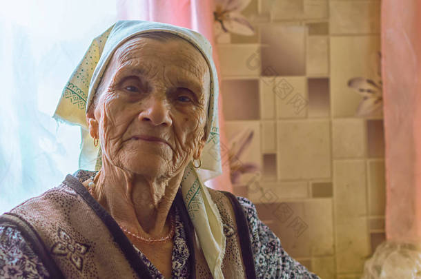 面对一个老单身妇女在养老院的头巾看着相机