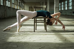 芭蕾舞者躺在一座旧建筑的木椅上的照片
