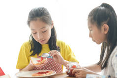 亚洲妹妹传播草莓果酱面包为她的妹妹
