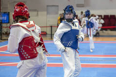 两个穿蓝色和红色拳道装备的女孩正在多阳战斗 