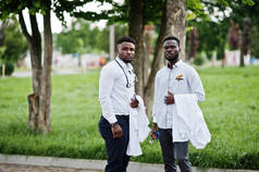 两个年轻的非洲裔美国男医生手拿白色外套