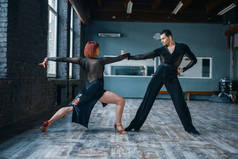 两名身着盛装的舞者在课堂上进行舞蹈训练。男女伴侣在工作室的专业对舞