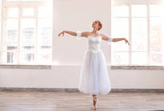 年轻优雅的芭蕾舞演员在白色演播室跳舞.