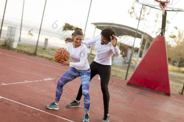 一群多民族青年在球场上打篮球